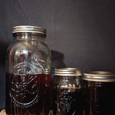 Mason jars filled with homemade vanilla extract, with vanilla beans steeping in the amber liquid