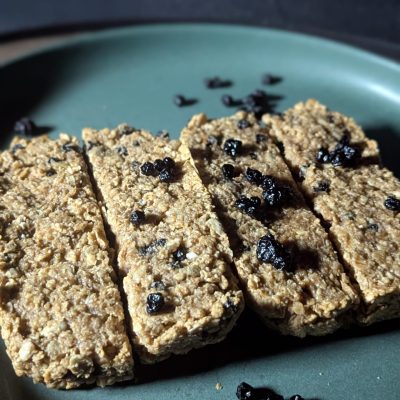 Golden Oat & Blueberry Protein Bars – Wholesome Energy in Every Bite Golden oat and blueberry protein bars arranged on an emerald green plate, showcasing their chewy texture and bursts of vibrant blueberries.